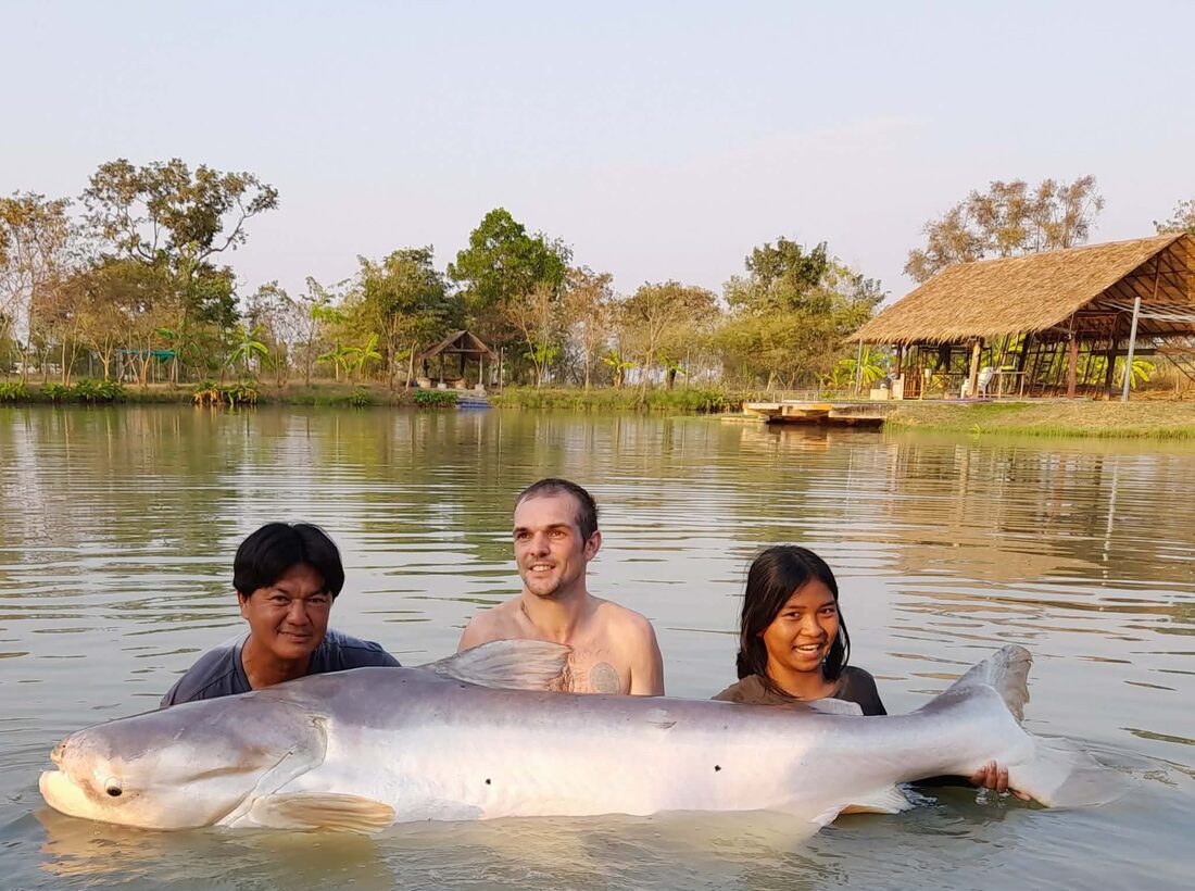 Group with a giant catfish in the lake